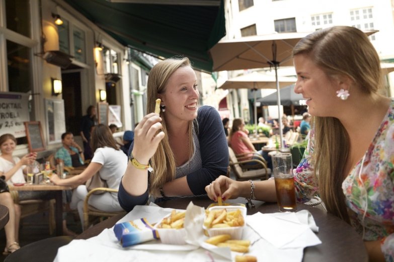 Девушки едят бельгийскую картошку фри