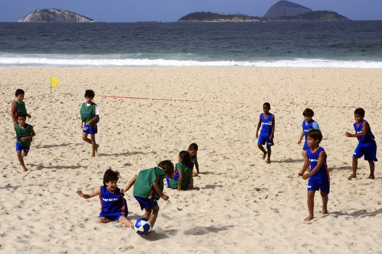 Дети играют в футбол на пляже